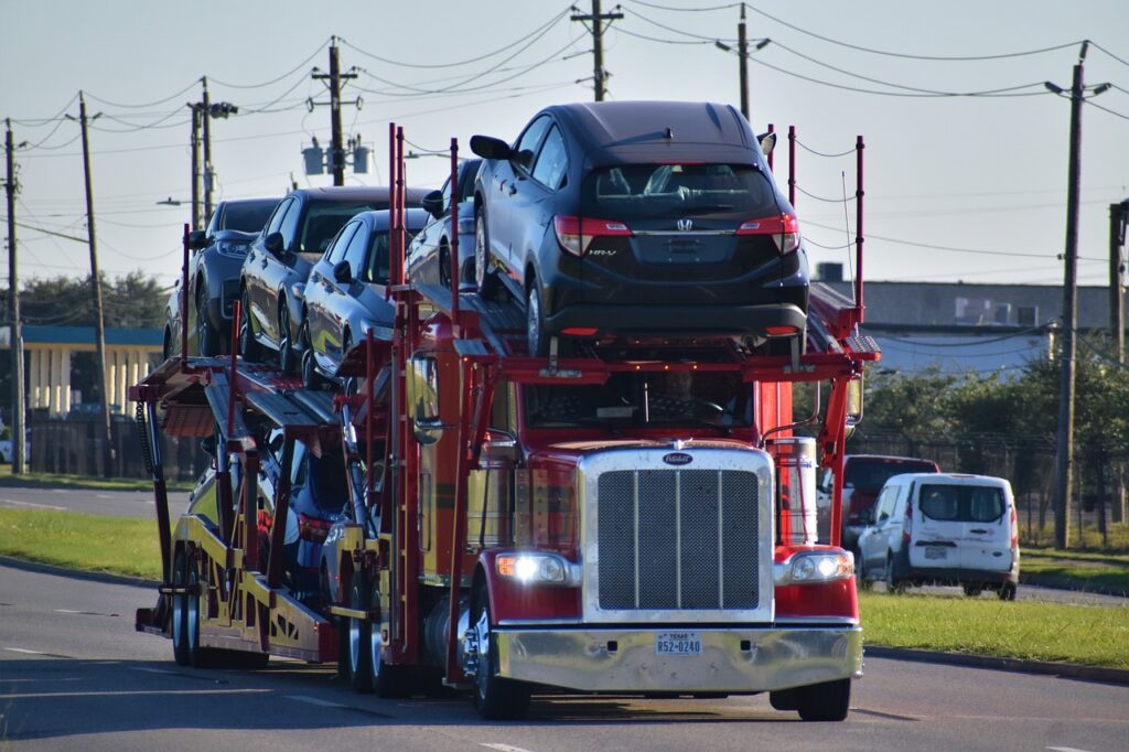 A red truck carrying a lot of small cars